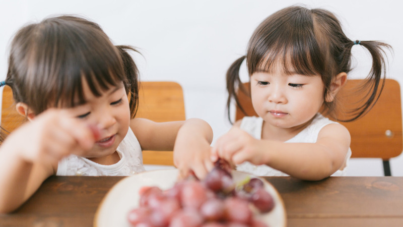 子どもが葡萄を食べている